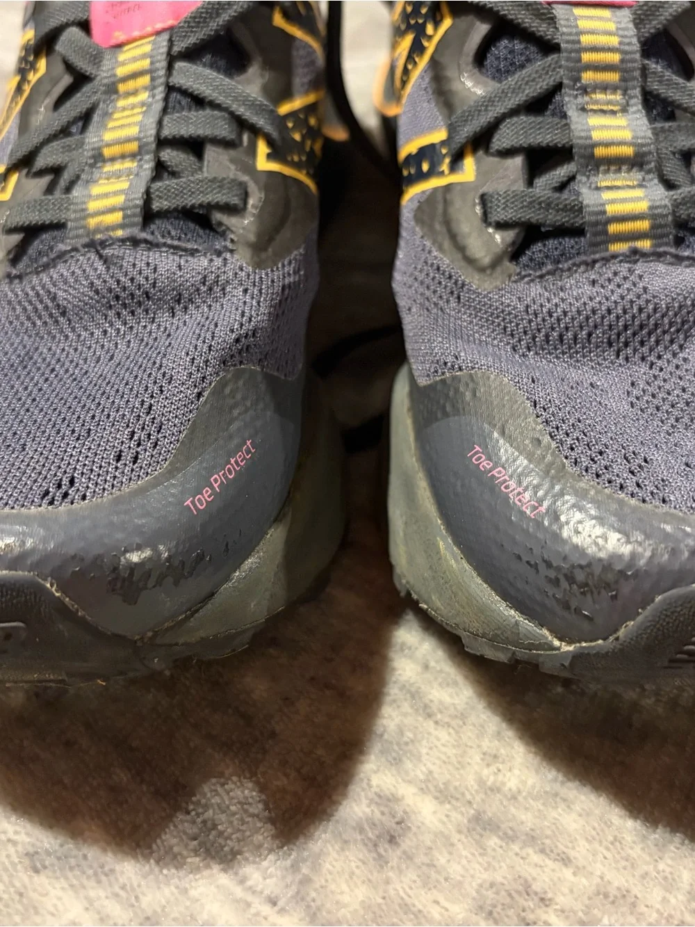 New Balance navy athletic sneakers with yellow and pink accents